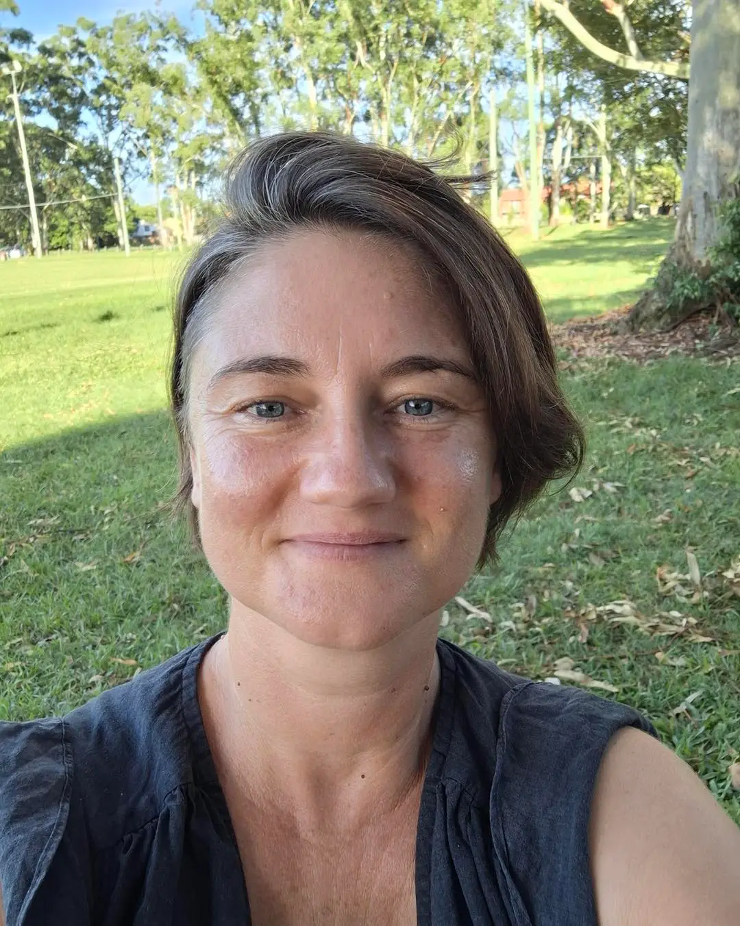 Workshop facilitator smiling outdoors in a park setting